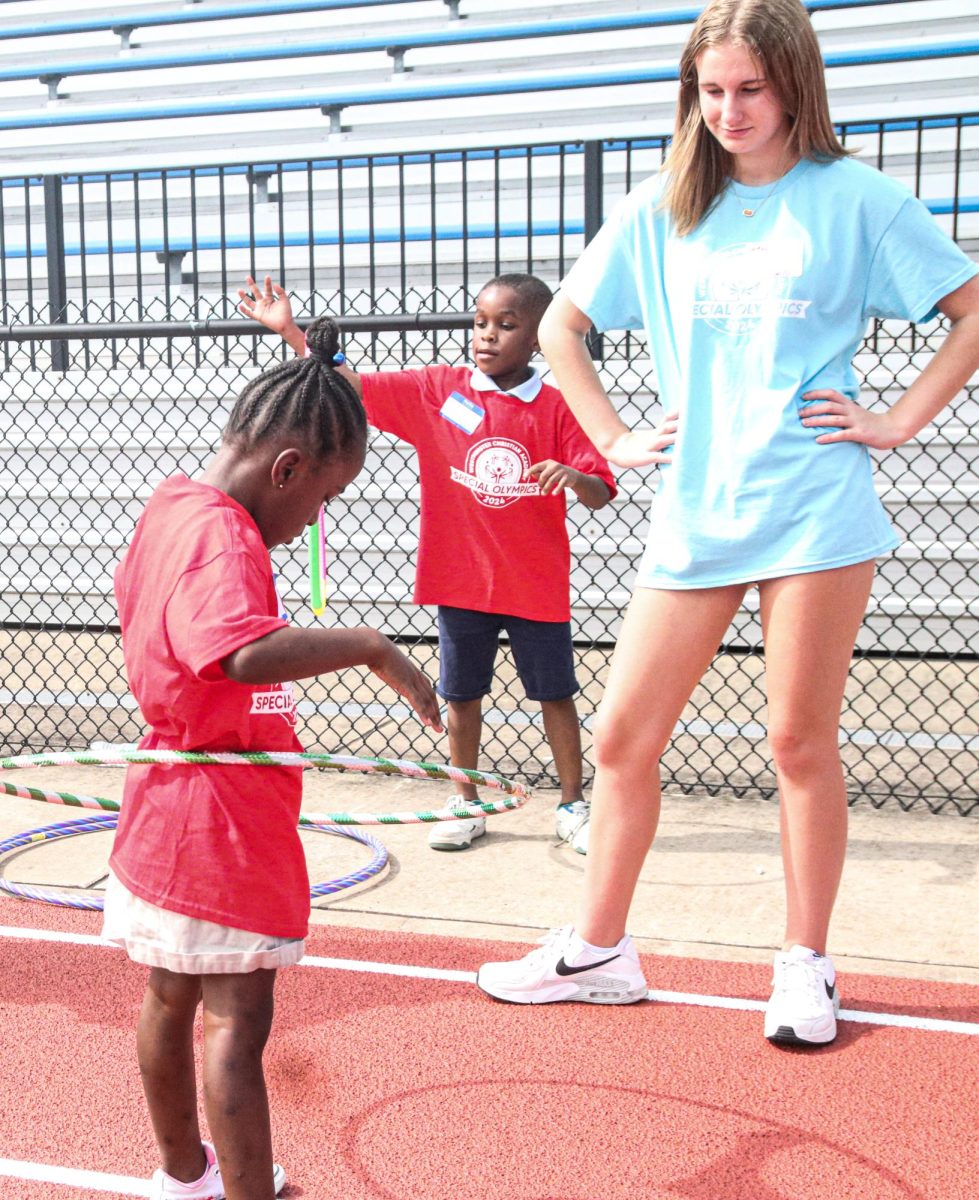 A special olympics athlete hula hoops with a student volunteer 