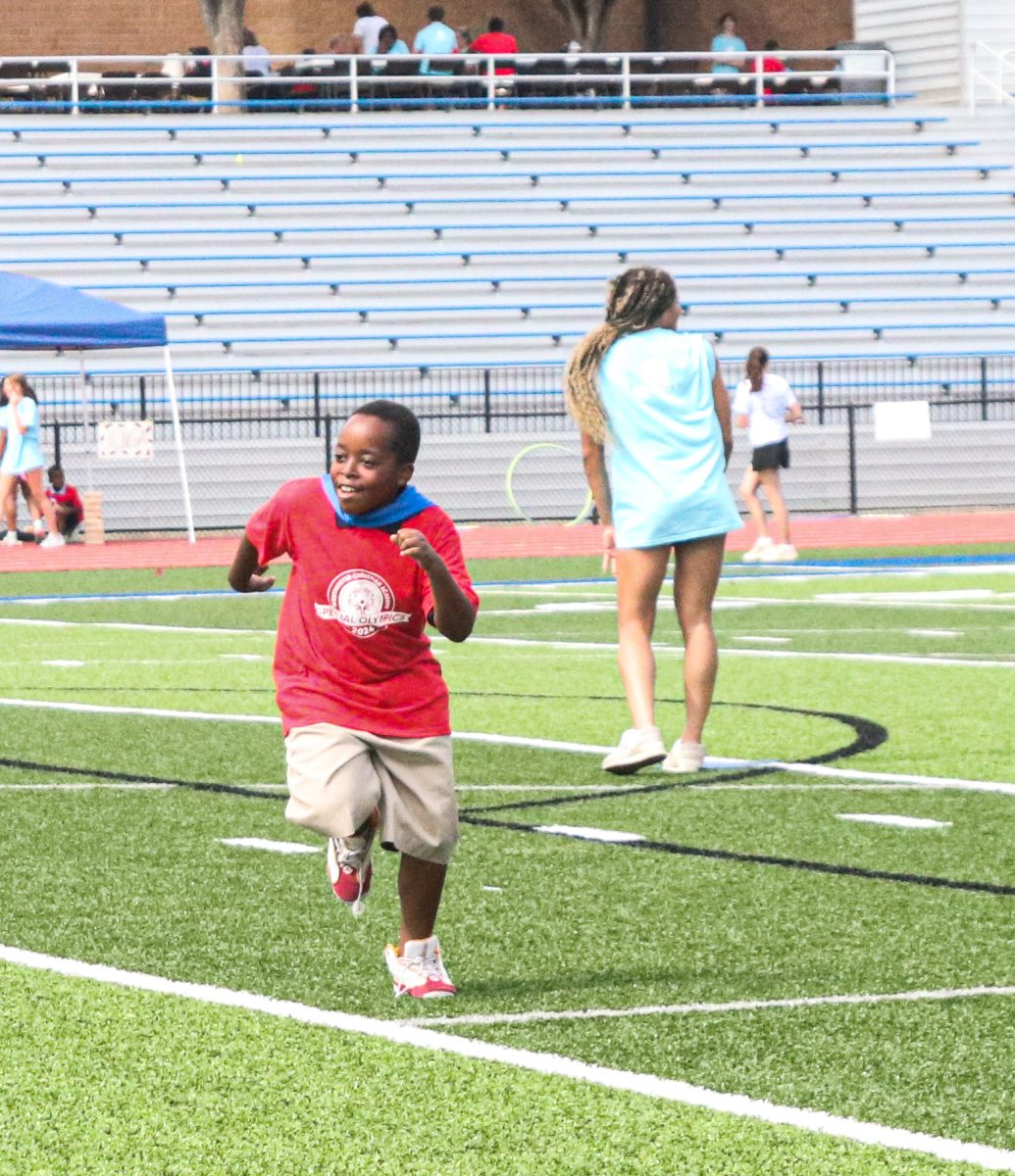 Special olympics athlete plays a game of kickball with volunteers and fellow athletes