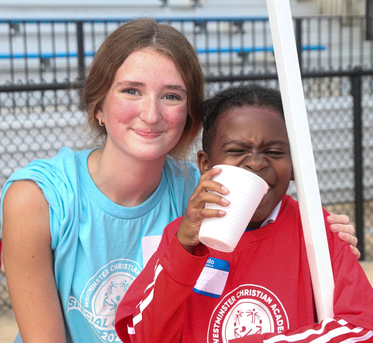 Student volunteer joins special olympics athlete to get a drink of water