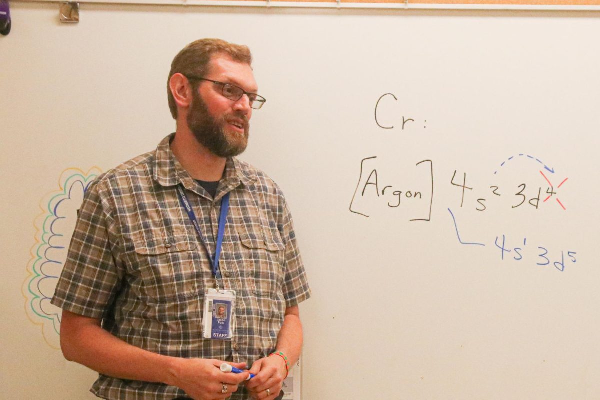 Jason Polk, Upper School Chemistry Teacher, explains electron configurations to student.