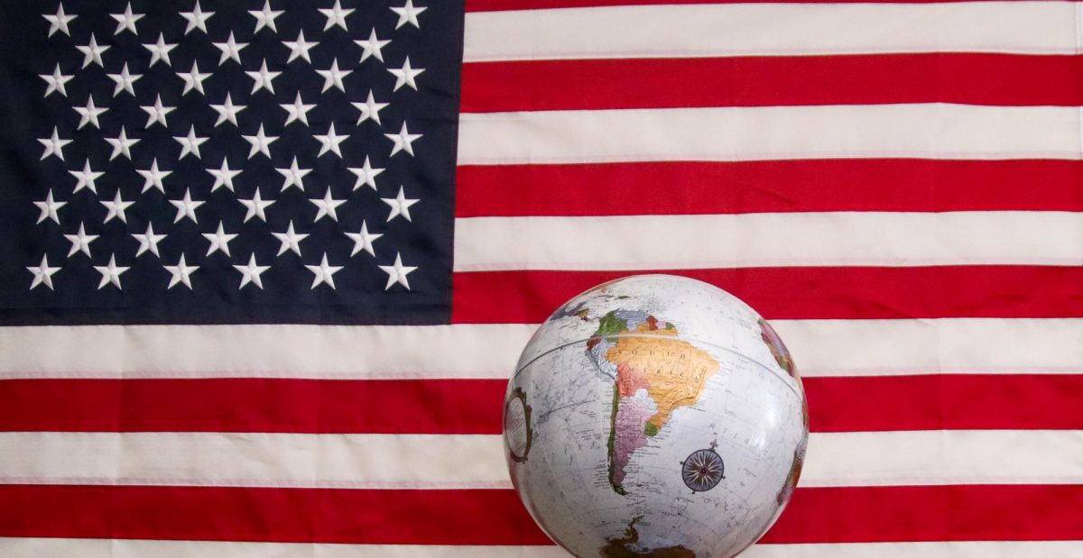 A globe being disproportionately shown against a United States flag. 