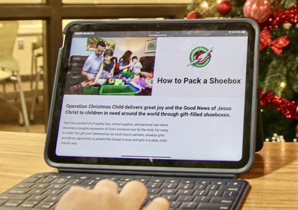 Student looks on the Operation Christmas Child website, learning how to pack a shoebox to help a child in need this Christmas season