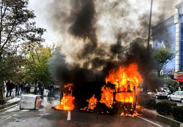 Bus on its side burning during Iranian fuel protests in 2019