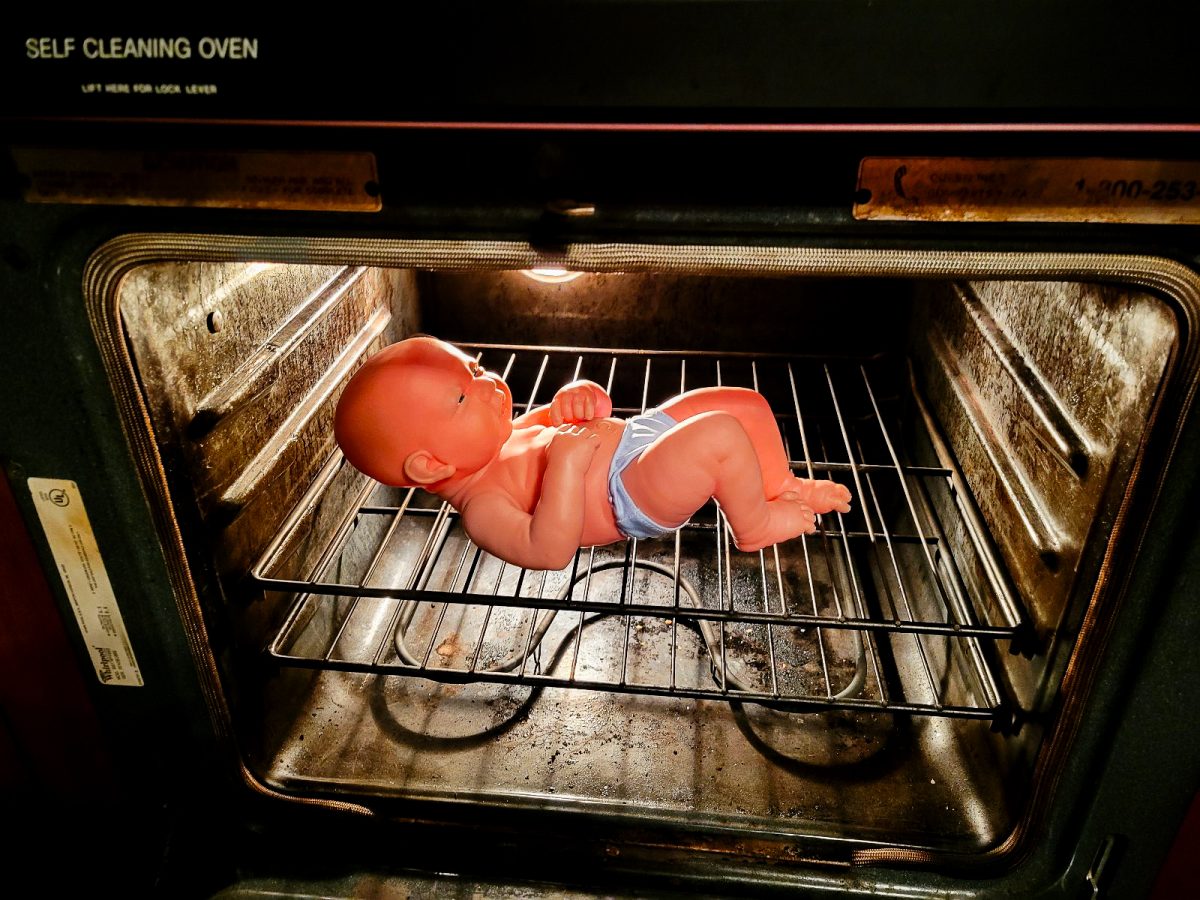 Prematurely born baby in an oven acting as an artificial womb.